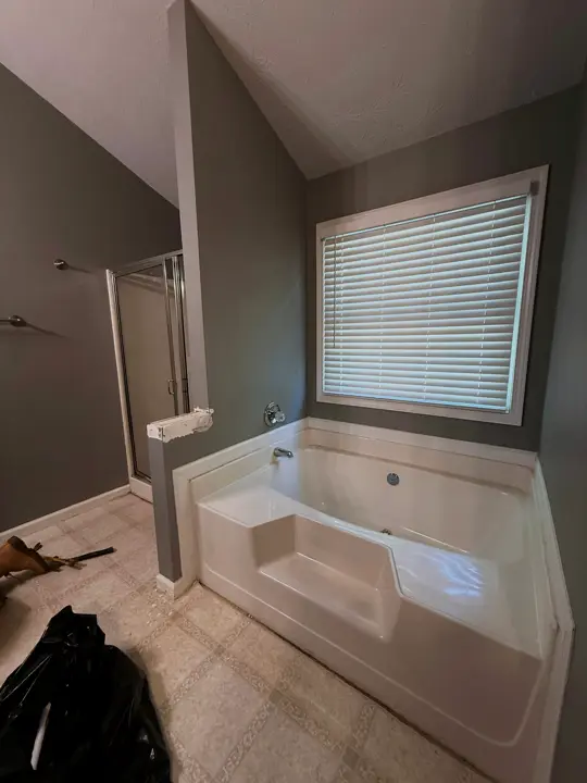 The master bath before: a dated drop-in tub and plain walls