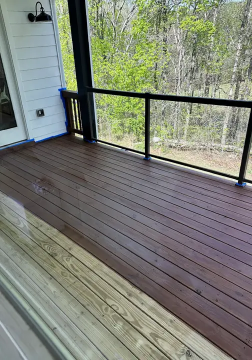 Screened porch deck, freshly stained, with black metal railing