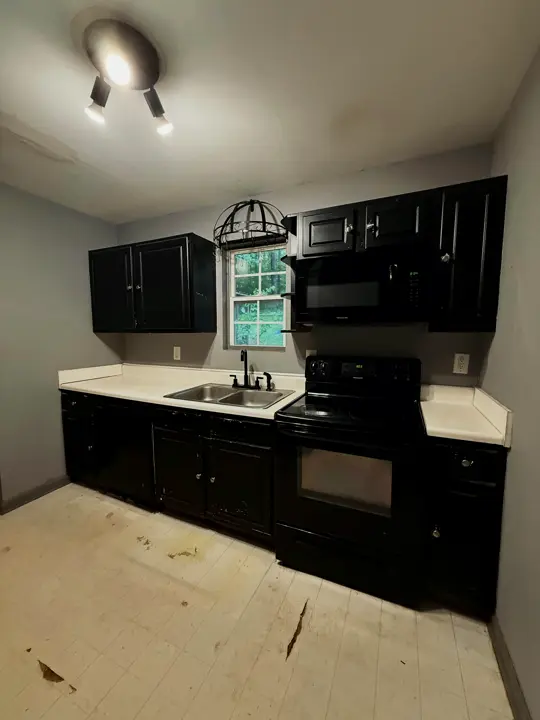 The kitchen before: dark worn cabinets and a laminate counter