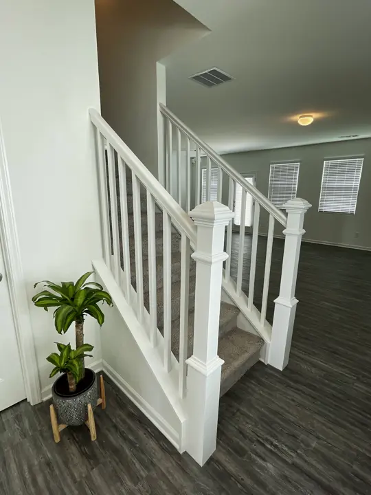 The staircase after: new white railing, newel posts and balusters over an LVP floor